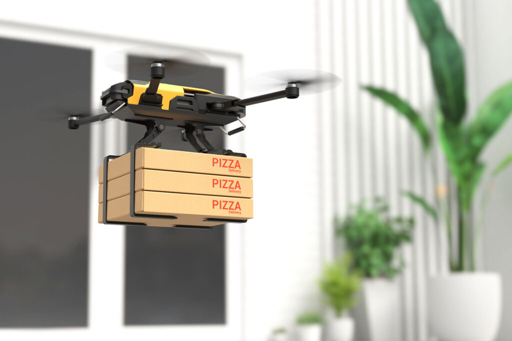 Delivery drone holding pizza boxes while floating in the air