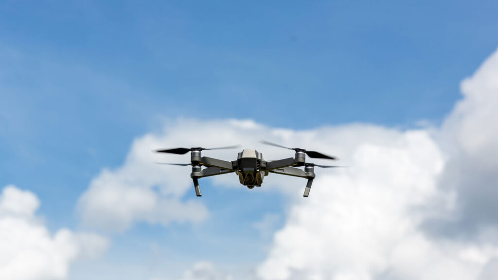 State standards for delivery drone ports signed into law, drone flying through the air in front of blue skies and clouds